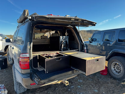 SUV with open tailgate showing custom wooden vehicle drawer storage system outdoors