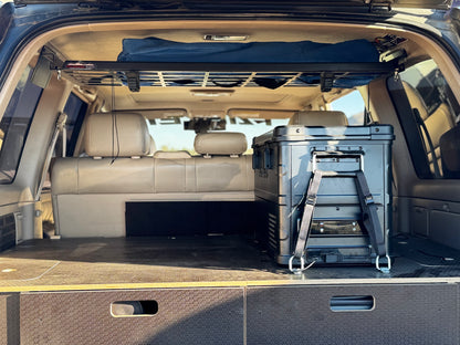 SUV rear cargo space with storage drawers, roof rack and large portable fridge
