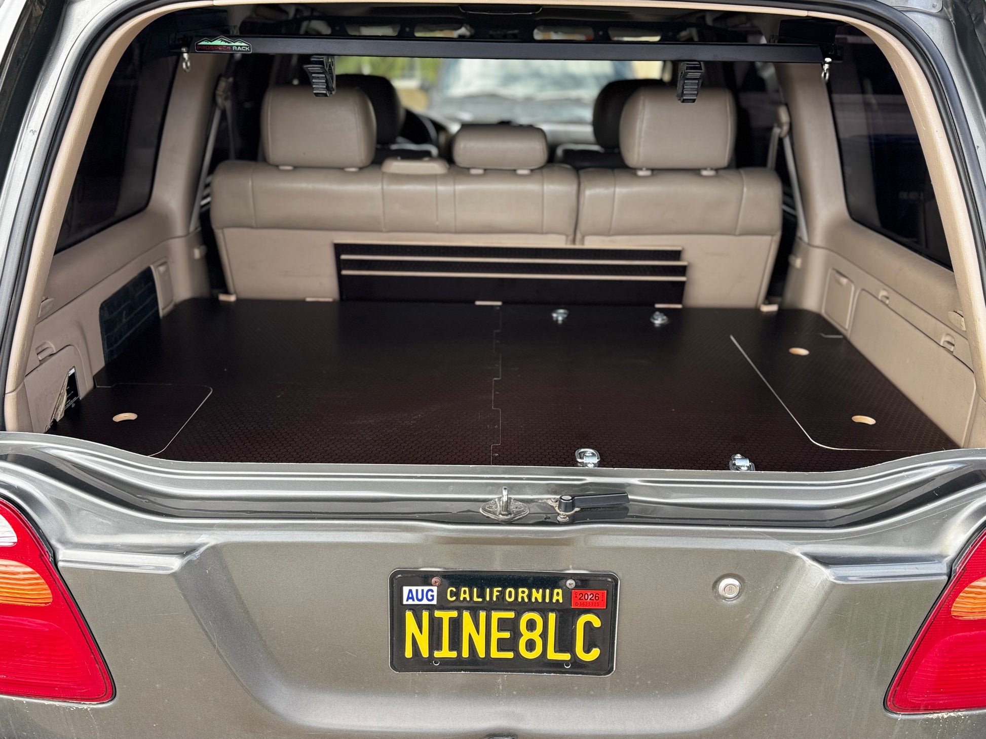 Vehicle rear cargo area with custom fitted solid wood storage drawer system installed