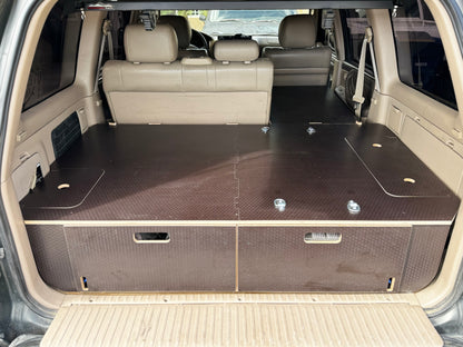 SUV rear cargo area with custom wood drawer storage and flat deck system installed