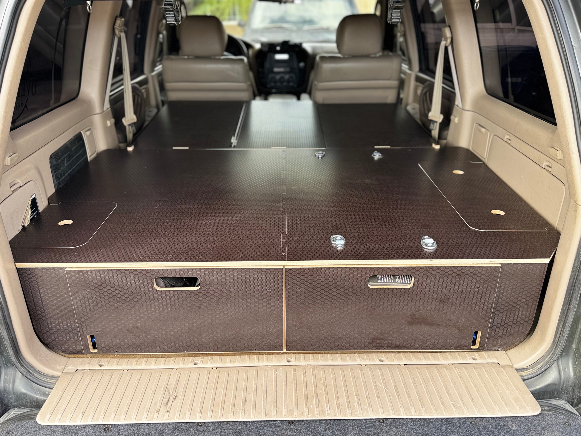 Custom wood vehicle drawer system installed in SUV cargo area for organized storage