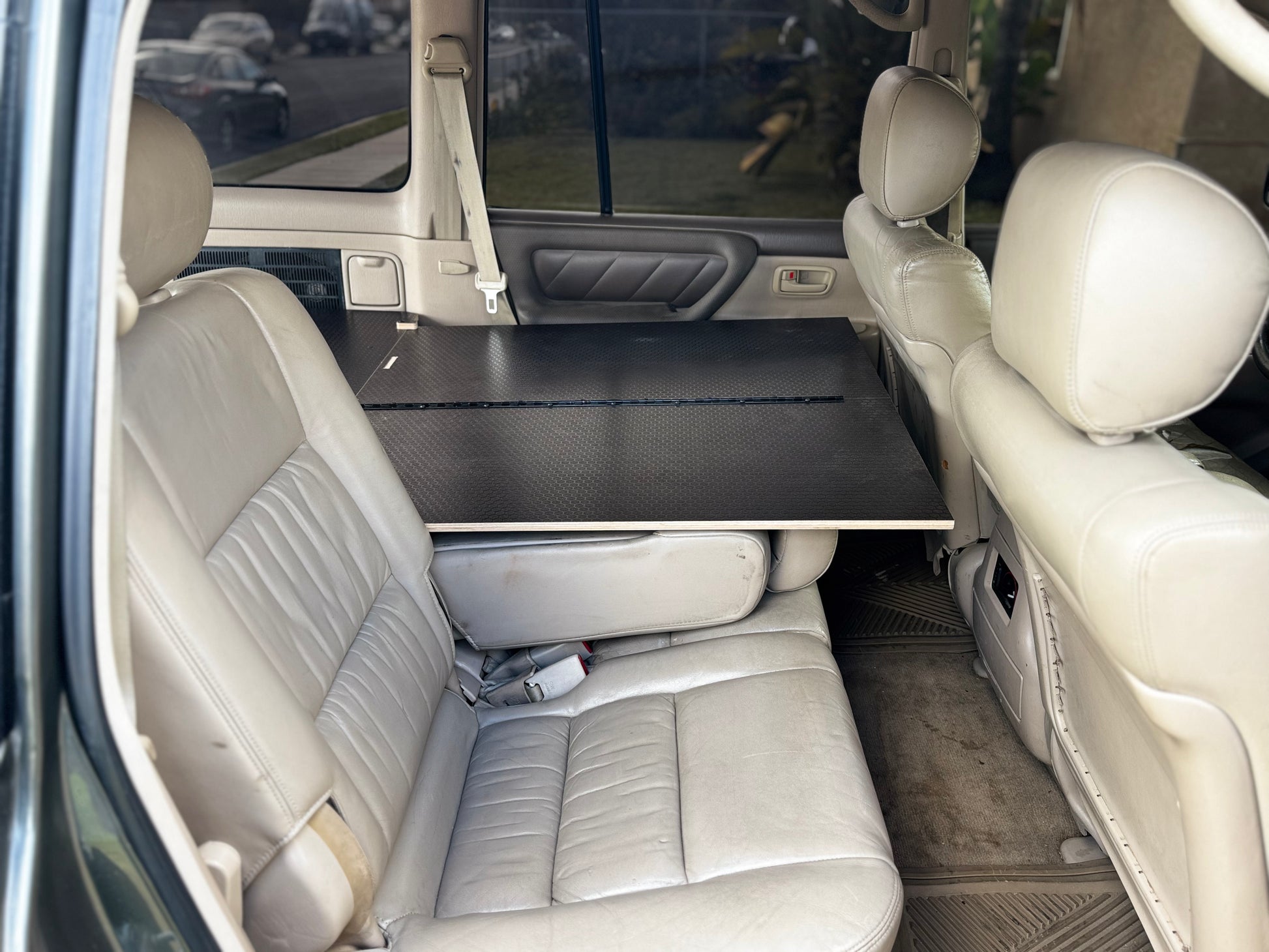 Vehicle back seat with foldable storage drawer system installed