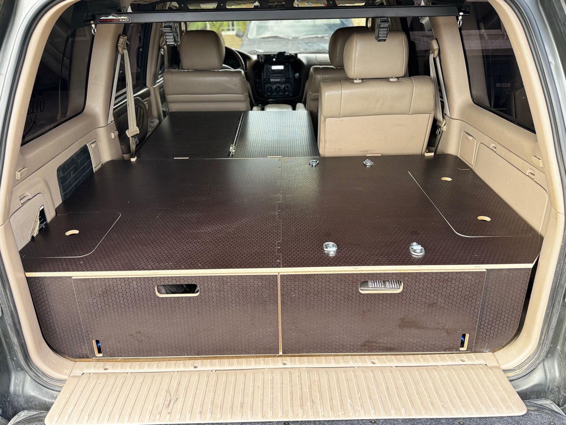 Custom wood drawer system installed in SUV cargo area for organized vehicle storage.