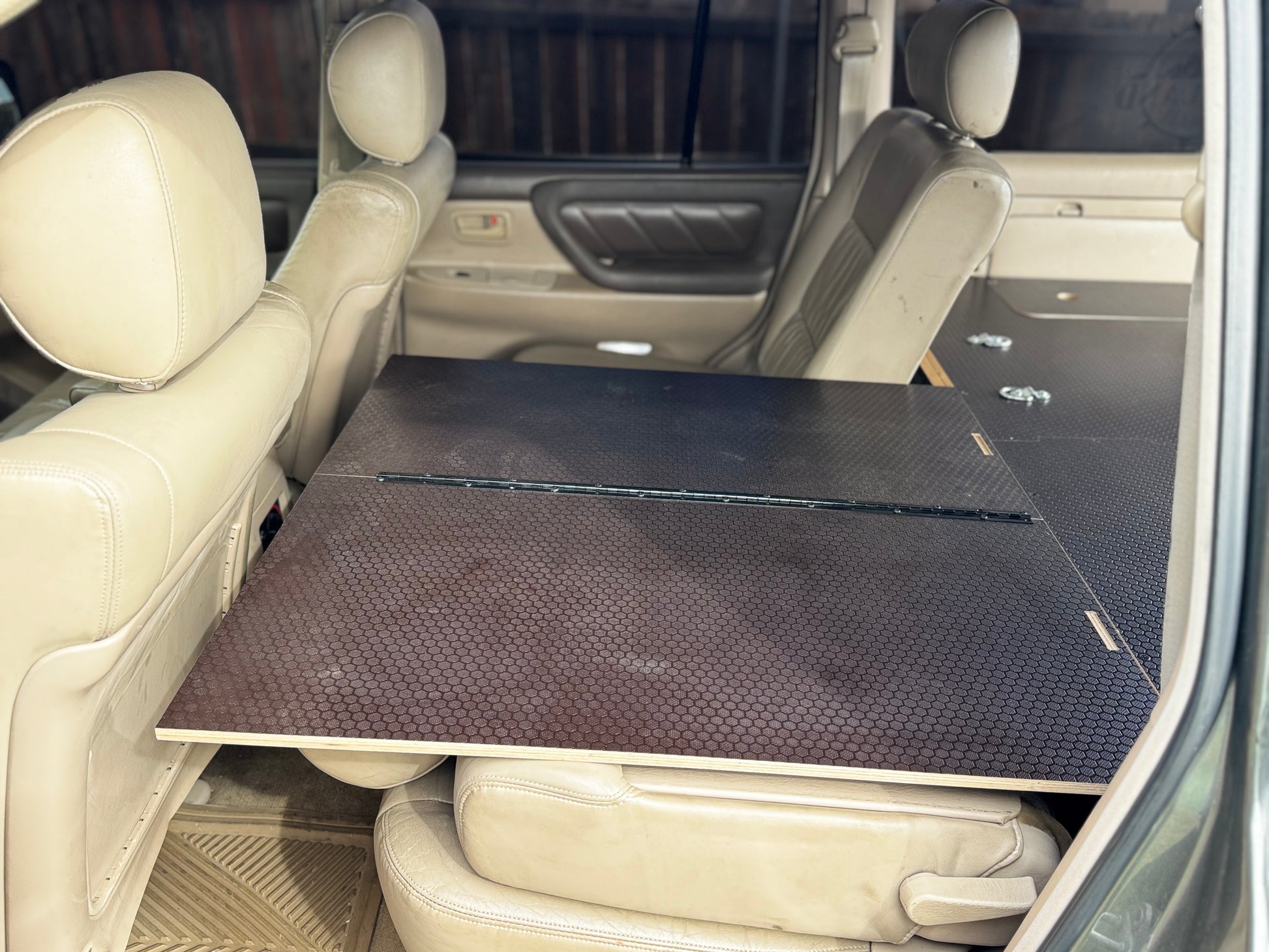 Foldable vehicle storage drawer system installed in the back seat area of an SUV