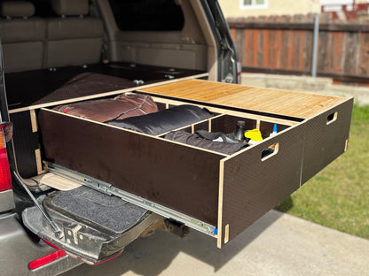 Pull-out solid wood vehicle drawer system loaded with gear and camping supplies