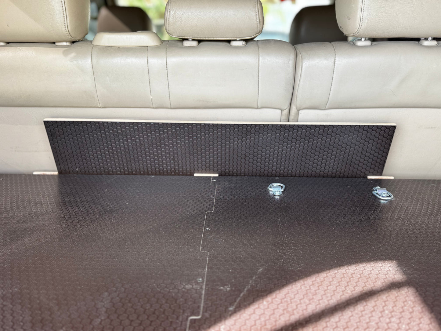 Vehicle trunk with custom wood storage drawer system and tie-down anchors