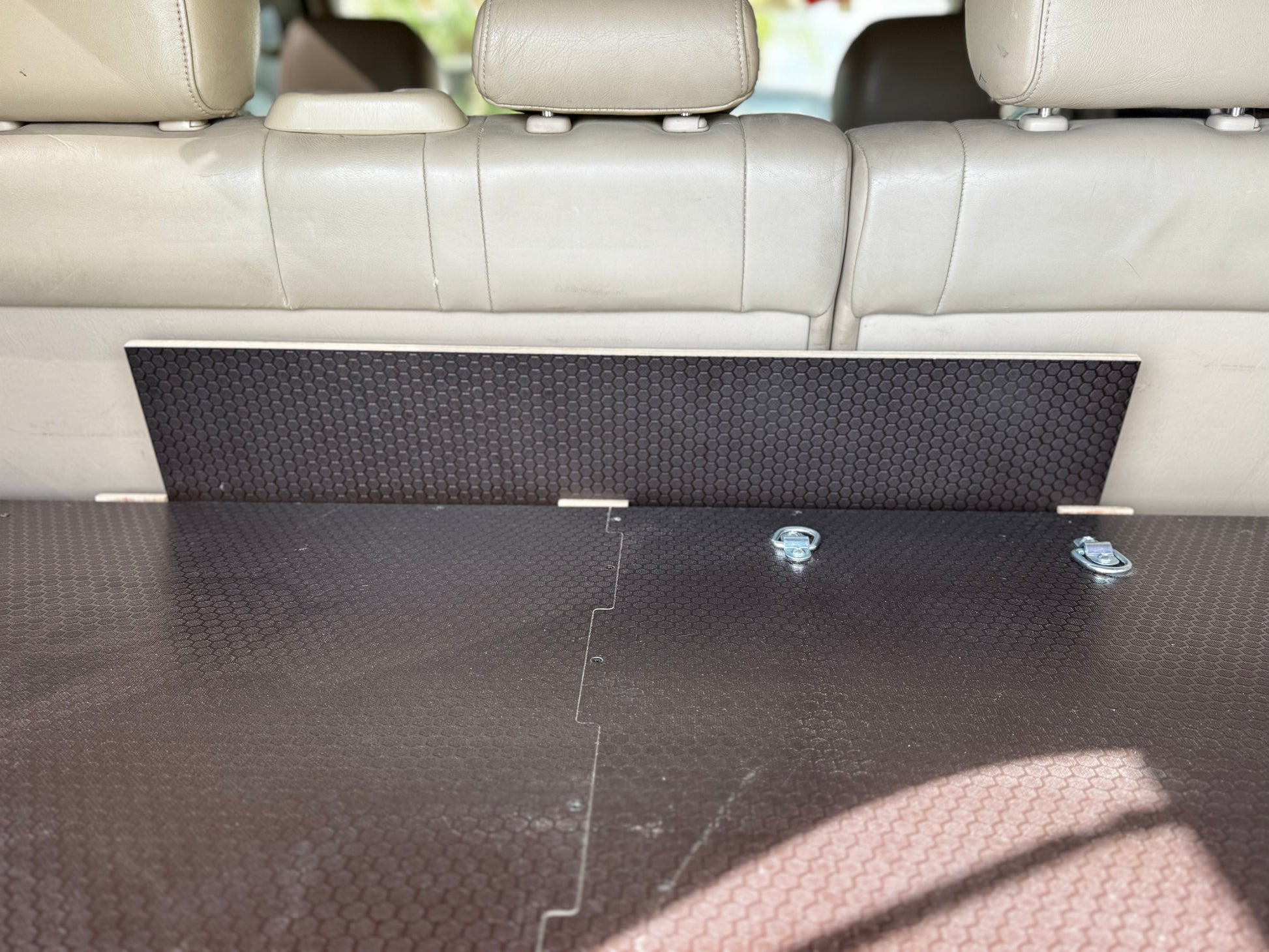 Vehicle trunk with custom wood storage drawer system and tie-down anchors