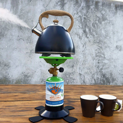 Black tea kettle heating on a portable green propane camping stove with a refillable cylinder.