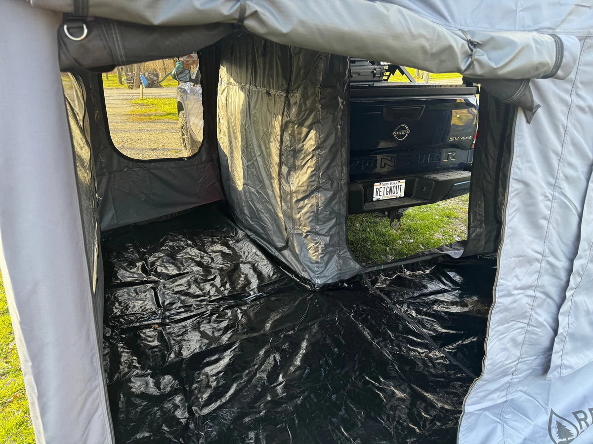Truck tent with waterproof floor attached to pickup bed, outdoor camping setup